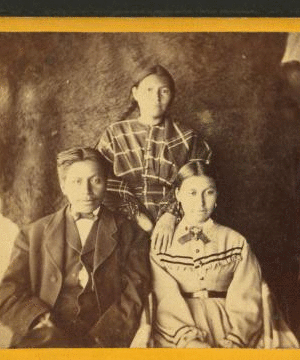 [Portrait of two young women and one young man, animal skin used as backdrop.] 1870?-1880?