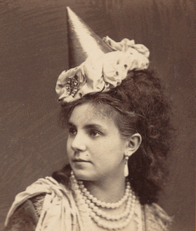 Woman wearing pearls and pointed hat