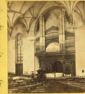 [Interior view of the Baptist chapel showing seats and pews and the organ above the altar.] 1865?-1885?