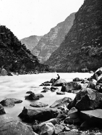 Clem Powell reading while sitting on a boulder in Cataract Canyon, Colorado River. Arizona.n.d.