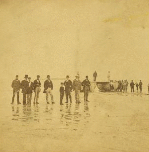 Landing of the French Atlantic telegraph cable on Duxbury Beach, with the officers of the steamers and barges that landed the cable on shore, in the foreground. 1860?-1880?