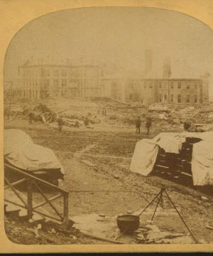 A view taken from the rear of the P. R. R. depot. In the middle ground are seen the stores and offices of the Cambria Iron Co., and in the foreground are coffins and bodies just arrived from the morgues and ready for shipment. 1889