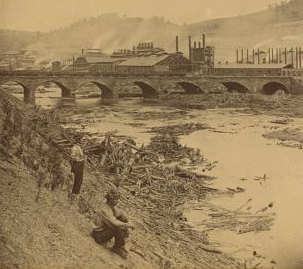 This view was taken after the debris was removed from above the bridge and shows the Cambria Iron Works in the distance. 1889