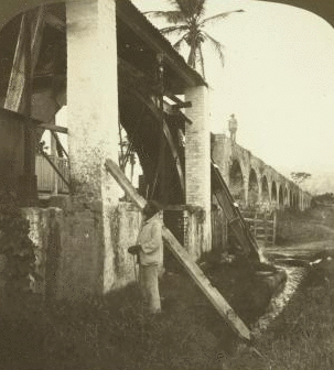 The OvershotWheel furnishing Power for Grinding, and the Picturesque Aqueduct bringing Water from the Mountains, Mona Sugar Estate, Jamaica. 1904