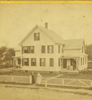 ["Two tenement" in Thorndike with owners at gate.] 1865?-1905?