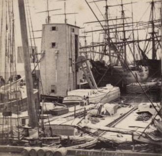 Looking along the docks, from Fulton Market, showing floating grain elevators. 1859?-1875? [ca. 1860]