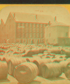 [Barrels in front of a large building.] 1860?-1895?