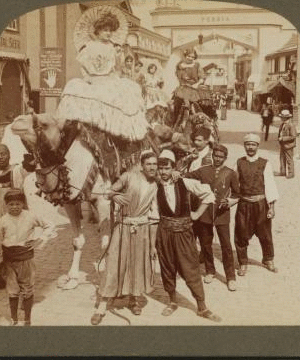 Dancing girls riding on camels through street in 'Mysterious Asia'. 1903-1905 1904