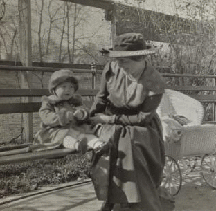 [Mother and child sitting in a park.] 1915-1919 October 1917
