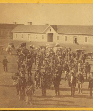 Taken at Fort Wingate, Dec. 11, 1871 [a group of native Americans and Burros in front of a building.] 1870?-1908