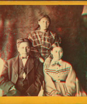 [Portrait of two young women and one young man, animal skin used as backdrop.] 1870?-1880?