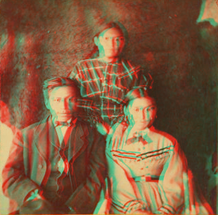 [Portrait of two young women and one young man, animal skin used as backdrop.] 1870?-1880?