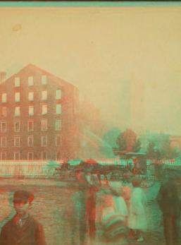 [View of a fire in large industrial building with men spraying water.] 1865?-1903 [187-]