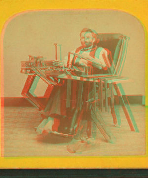 [Studio portrtait of a man, possibly handicapped, in specially outfitted chair where he is shown building picture frames.] 1869?-1885?