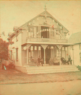 [People on the porch of a decorated cottage.] 1865?-1880?