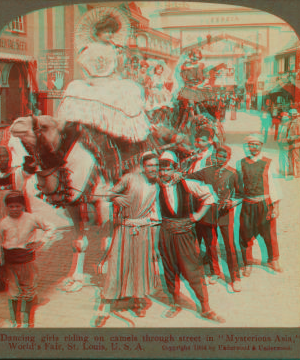 Dancing girls riding on camels through street in 'Mysterious Asia'. 1903-1905 1904