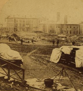 A view taken from the rear of the P. R. R. depot. In the middle ground are seen the stores and offices of the Cambria Iron Co., and in the foreground are coffins and bodies just arrived from the morgues and ready for shipment. 1889