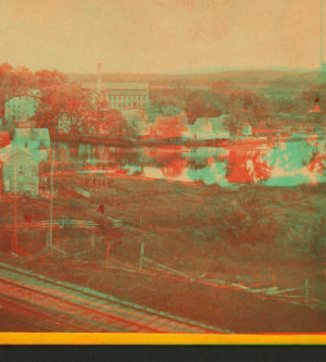 [View of unidentified industrial buildings on a river.] 