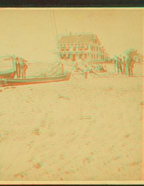 [Men standing near boats on the beach, Our House in the background.] 1859?-1880?