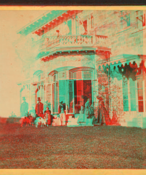 [Family posing in front and in the balcony of stone house.] 1860?-1869?