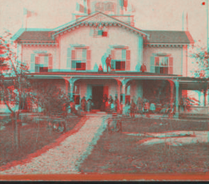 [View of people standing in the verandah and one man standing on the roof.] 1870?-1890?