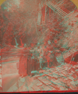 [Two women and a man sitting on the rocks in Glen Cathedral.] 1865?-1880?