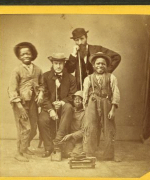 Shoe Blacks. [Studio portrait of three young shoe shiners and their customers.] 1868?-1900?