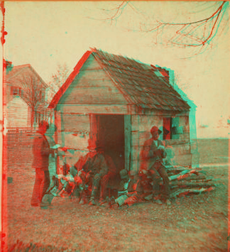 Uncle Abe's schoolhouse and scholars. [Man in a top hat in front of a shack with several boys with books.] 1868?-1900?