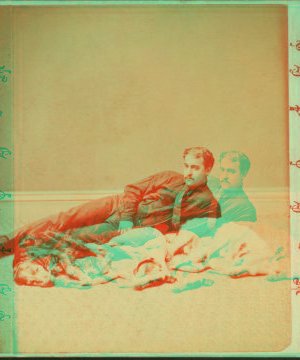 [Studio portrait of a man lying next to 3 dogs.] 1865?-1905?