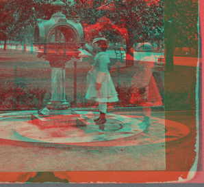 Drinking fountain on the mall. [Girl in a dress at the fountain.] 1860?-1905?