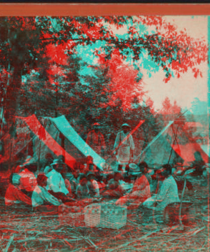 [Group of people, including children, with two tents and a woven basket.] 1870?-1890?