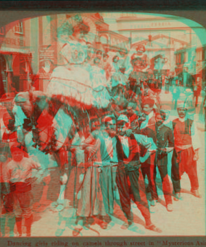 Dancing girls riding on camels through street in 'Mysterious Asia'. 1903-1905 1904