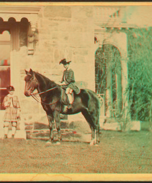 [Girl on horseback in front of house.] 1860?-1869?