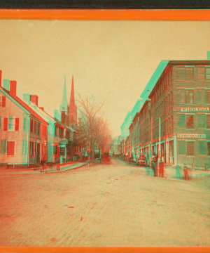 [Street view showing commercial buildings and church.] 1865?-1880?