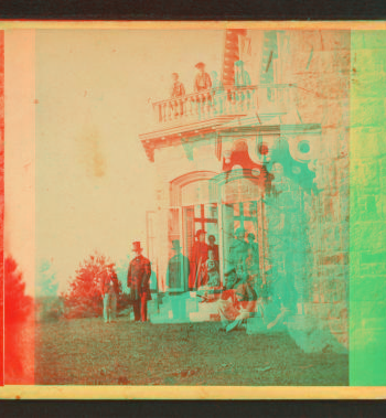 [Family posing in front and in the balcony of stone house.] 1860?-1869?