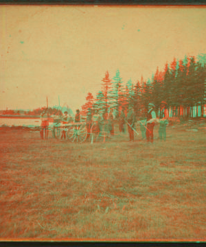 [View of a group of people standing with a canon, with trees in the background.] 