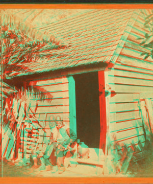 [Man sitting in front of a cabin.] 1868?-1900?