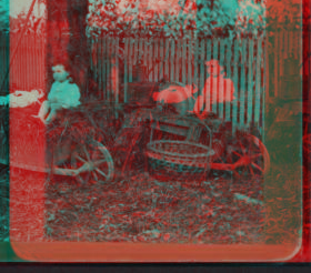 [A child sitting in a wheelbarrow with her doll, ax sharpener, rake, basket and watering can nearby.] [ca. 1880] 1870?-1890?