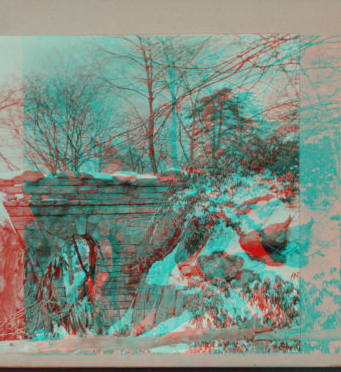 [View of snow covered rocks and bridge.] 1915-1919 March 1916