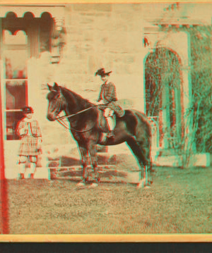 [Girl on horseback in front of house.] 1860?-1869?