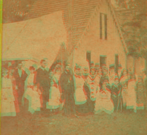 [Group portrait of people in front of tent and cottage.] 1870?-1880?