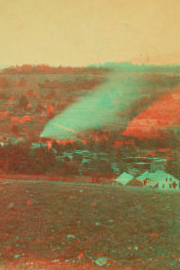 [View of a valley with trees, houses and a plume of smoke(?).] 1869?-1885?