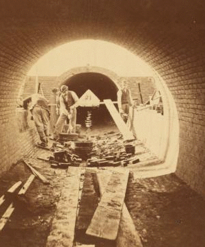 Sudbury River Conduit, B.W.W., div. 4, sec. 15, Nov. 13, 1876. View from inside of conduit; brickmasons at work in the east terminal chamber of bridge. 1876?-1878?