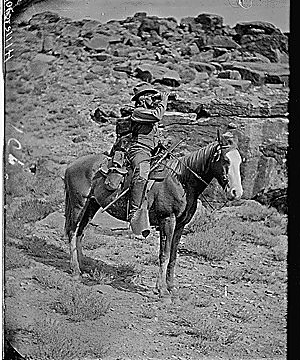 Prof. A.H. Thompson on his horse "Old Ute", looking through field glasses, about 1873. Old nos. 441, 468, 459, 661. See 663 also.