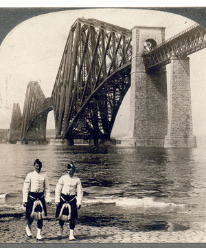 Highlanders in native costume at the great Forth Bridge, one and one-half miles long, spanning the Firth of Forth, Queensferry, Scotland