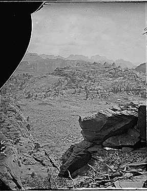 Colob country. Southern Utah. Buttes of the Mookovutoweap branch of the Virgin in the distance. Springdale Village is just on the other side of the square topped butte. "Point marked with check is the great Temple or as the Mormons call it, 'Steamboat Roc