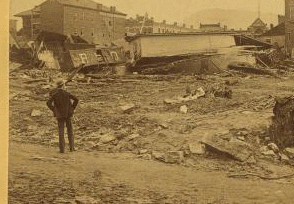 Looking towards the Merchantsí Hotel from the rear, showing B. & O. box car loaded with pig iron, lodged in the debris after being washed two squares from the track. 1889