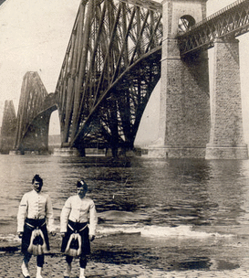 Highlanders in native costume at the great Forth Bridge, one and one-half miles long, spanning the Firth of Forth, Queensferry, Scotland