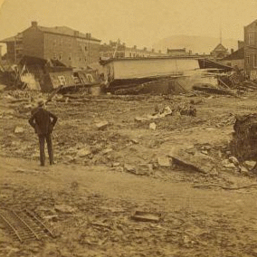 Looking towards the Merchantsí Hotel from the rear, showing B. & O. box car loaded with pig iron, lodged in the debris after being washed two squares from the track. 1889