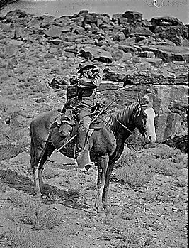 Prof. A.H. Thompson on his horse "Old Ute", looking through field glasses, about 1873. Old nos. 441, 468, 459, 661. See 663 also.